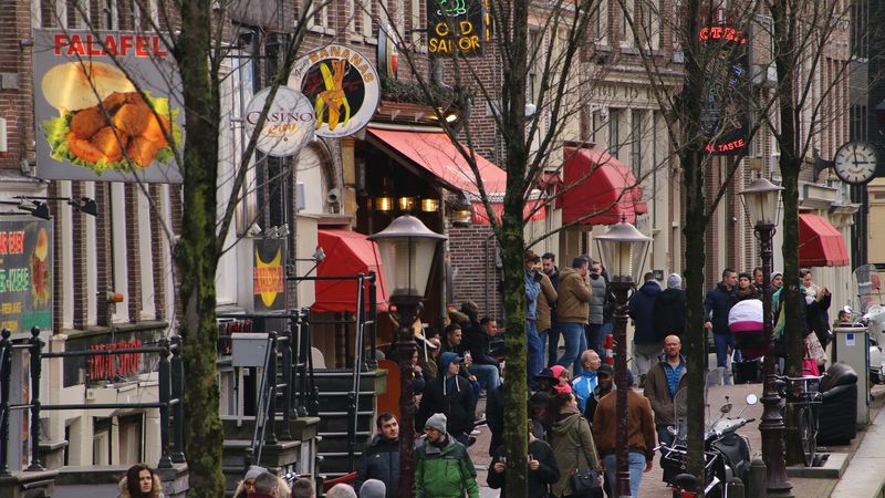Amsterdam red light district during day busy street view people walking